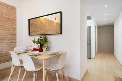 a dining room with a table and white chairs at Apartment Eduardo in Barcelona