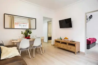 a white living room with a table and a tv at Apartment Eduardo in Barcelona