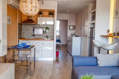 a kitchen and living room with a couch and a table at Seaside Cozy Apartment by Hello Homes Sitges in Sitges