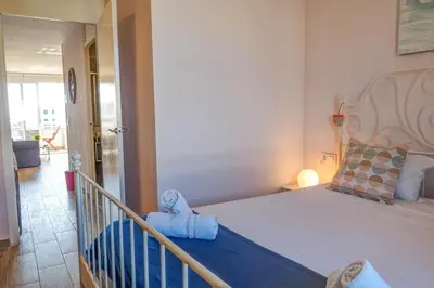 a bedroom with a large bed and a balcony at Seaside Cozy Apartment by Hello Homes Sitges in Sitges