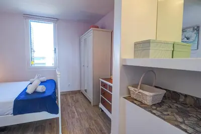 a small bedroom with a bed and a window at Seaside Cozy Apartment by Hello Homes Sitges in Sitges