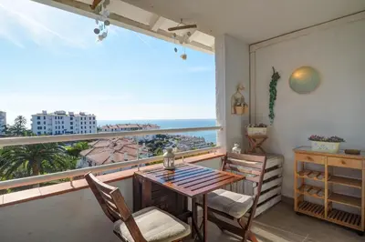 a balcony with a table and chairs and a view of the ocean at Seaside Cozy Apartment by Hello Homes Sitges in Sitges
