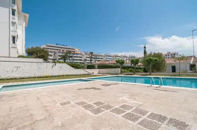 an empty swimming pool in the middle of a building at Seaside Cozy Apartment by Hello Homes Sitges in Sitges