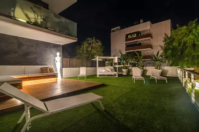 a patio with a table and chairs on a lawn at Sitges Spaces Garden Paradise 3 bedroom, 3 bathroom, huge PRIVATE garden-terrace, pool- sleeps up to 8 in Sitges
