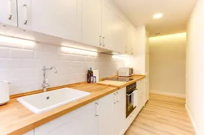 a kitchen with white cabinets and a white sink at Bright 2bdr In Trendy Gracia in Barcelona