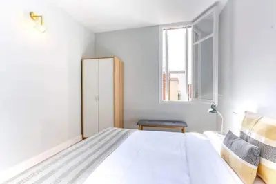 a bedroom with a white bed and a window at Bright 2bdr In Trendy Gracia in Barcelona