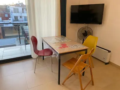 a table and chairs in a room with a tv at Terraza Relajante Galvani in Terrassa