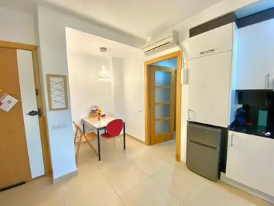 a kitchen and dining room with a table and a refrigerator at Terraza Relajante Galvani in Terrassa