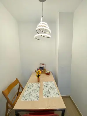 a dining room table with aendant light and a table and chairs at Terraza Relajante Galvani in Terrassa