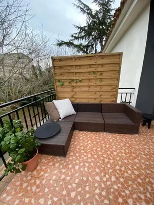a patio with a bench on a balcony at Charming apartment in a duplex with garden & balcony in Cunit