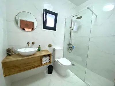 a bathroom with a sink and a toilet and a mirror at Charming apartment in a duplex with garden & balcony in Cunit
