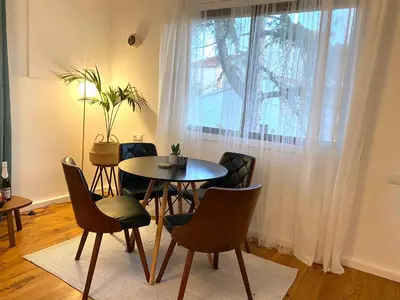 a dining room with a table and chairs and a window at Charming apartment in a duplex with garden & balcony in Cunit