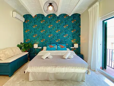 a bedroom with a bed and a blue wall at Abbott apartment - 1 min from the beach - 100m2 - sleeps 8 in Sitges