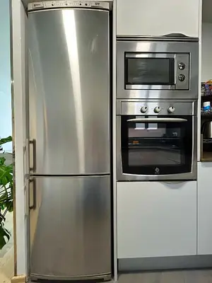 a stainless steel refrigerator next to a microwave at Abbott apartment - 1 min from the beach - 100m2 - sleeps 8 in Sitges