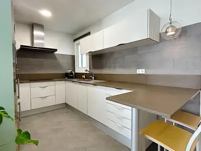 a kitchen with white cabinets and a counter top at Abbott apartment - 1 min from the beach - 100m2 - sleeps 8 in Sitges