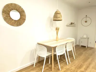 a dining room table with white chairs and a mirror at Lovely New apartment 20 minutes from Barcelona center. in Barcelona