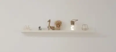 a white shelf with plants and candles on it at Lovely New apartment 20 minutes from Barcelona center. in Barcelona