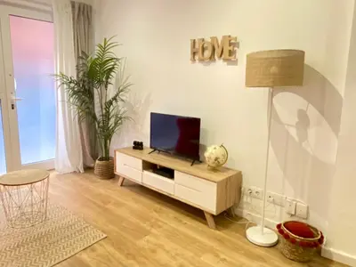 a living room with a flat screen tv on a cabinet at Lovely New apartment 20 minutes from Barcelona center. in Barcelona