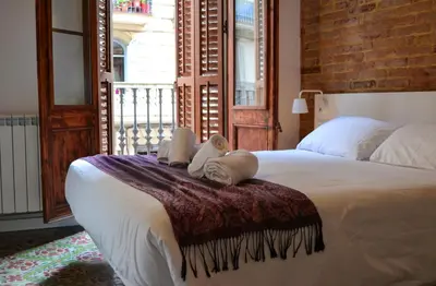 a bedroom with a large bed with towels on it at Happy People Plaza España Apartments in Barcelona