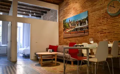 a living room with a brick wall and a table and chairs at Happy People Plaza España Apartments in Barcelona