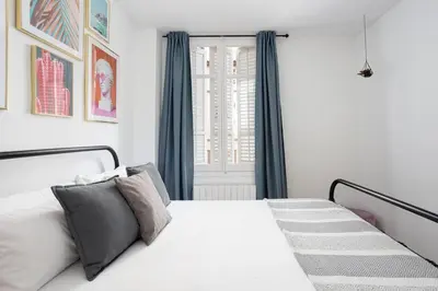 a bedroom with a white bed and a window at Livefull 2bdr In Trendy Gracia in Barcelona