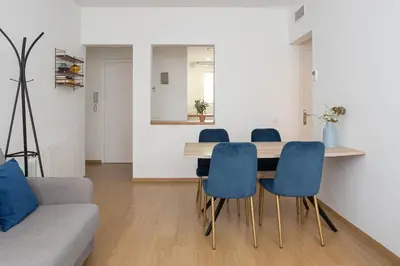a living room with a table and blue chairs at Livefull 2bdr In Trendy Gracia in Barcelona