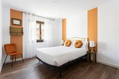 a bedroom with a bed with orange pillows on it at Stylish&bright Close To Subway in Esplugues de Llobregat