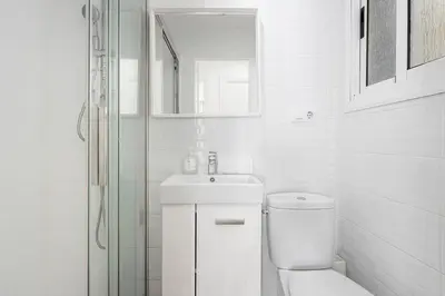 a white bathroom with a toilet and a sink at Stylish&bright Close To Subway in Esplugues de Llobregat