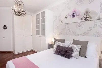 a bedroom with a white bed with pillows and a chandelier at Central 2 Bedroom By Sagrada Familia in Barcelona