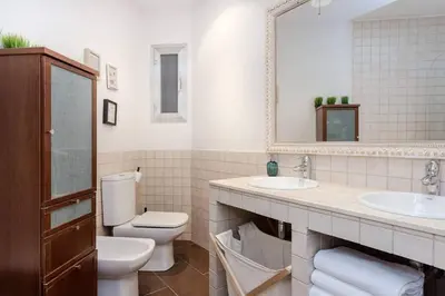 a bathroom with a toilet and two sinks and a mirror at Central 2 Bedroom By Sagrada Familia in Barcelona