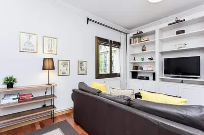 a living room with a couch and a tv at Central 2 Bedroom By Sagrada Familia in Barcelona