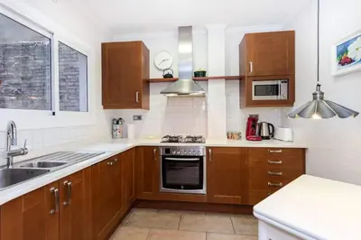 a kitchen with wooden cabinets and a stove top oven at Central 2 Bedroom By Sagrada Familia in Barcelona