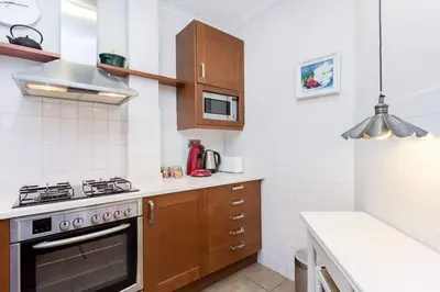 a kitchen with wooden cabinets and a stove top oven at Central 2 Bedroom By Sagrada Familia in Barcelona