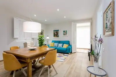 a living room with a wooden table and a blue couch at Lovely Designed House Connected To Center in Cornellà de Llobregat