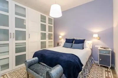 a bedroom with a king sized bed and a chair at Lovely Designed House Connected To Center in Cornellà de Llobregat