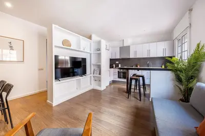 an open kitchen and living room with white cabinets at Caliu Apartments Barcelona - Fira in Hospitalet de Llobregat
