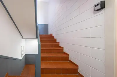 a staircase in a building with a brick wall at Caliu Apartments Barcelona - Fira in Hospitalet de Llobregat