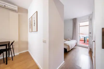 a room with a hallway with a bed and a table at Caliu Apartments Barcelona - Fira in Hospitalet de Llobregat