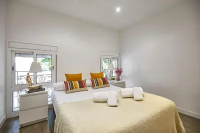 a white bedroom with a large bed with towels on it at BBarcelona Sant Pau Flat in Barcelona