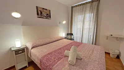 a bedroom with a bed with a white towel on it at Hostal La Premsa in Arenys de Mar