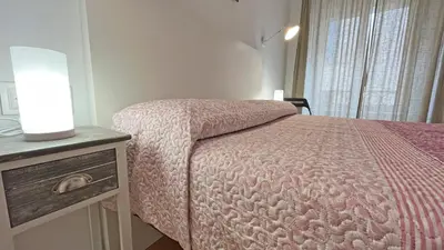 a bedroom with a bed with a pink comforter at Hostal La Premsa in Arenys de Mar