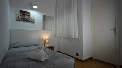 a bedroom with a bed with a towel on it at Hostal La Premsa in Arenys de Mar