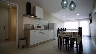a kitchen with a table with chairs and a refrigerator at Hostal La Premsa in Arenys de Mar