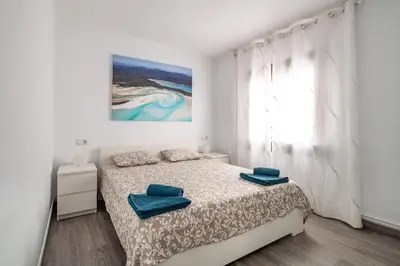 a white bedroom with a bed and a window at LOVELY APARTMENT Barca 2 in Sant Adria de Besos