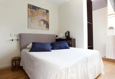a bedroom with a large white bed with blue pillows at rentBCN Gracia Jardinets in Barcelona