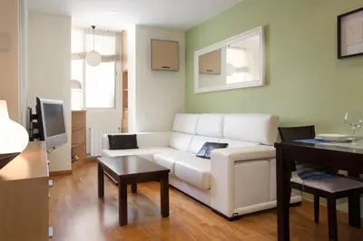 a living room with a white couch and a table at rentBCN Gracia Jardinets in Barcelona