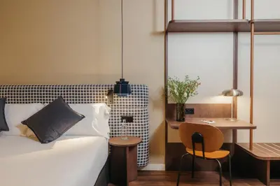 a bedroom with a bed and a table and a chair at H Regas Adults Only in Barcelona