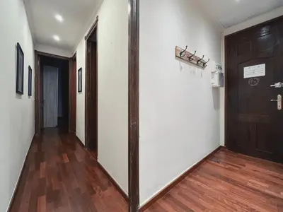 a hallway with white walls and a wooden door at Stay U-nique Apartments Industria II in Barcelona