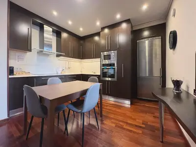 a kitchen with a wooden table and blue chairs at Stay U-nique Apartments Industria II in Barcelona