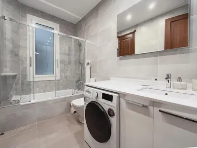 a bathroom with a washing machine and a sink at Stay U-nique Apartments Industria II in Barcelona